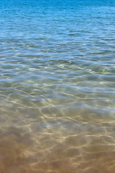 Fondo marino de verano. Textura de la superficie del agua. Patrón de ondulación de agua azul brillante. — Foto de Stock