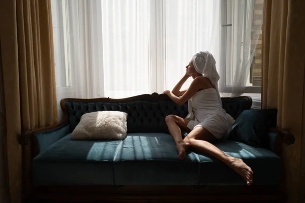 Girl resting and laying in cozy sofa bed in the luxury bedroom an easy morning. Attractive sexy woman relaxing wearing bathrobes and towels in hotel room. Lovely tenderness girlgriend — Stock Photo, Image