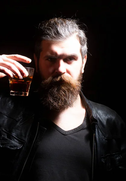 Man drinking whiskey, brandy, cognac. Man with glass of brandy. Bearded hipster with glass of whiskey. Old traditional whiskey drink - gentlemans beverage. Barman serves cognac. — Stock fotografie