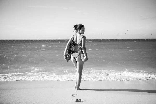Weiblich mit sexy Gesäß im Badeanzug. Junge Frau mit einer Ananas in der Hand. Heißer Sommerurlaub am Jamaika- oder Miami-Strand. — Stockfoto