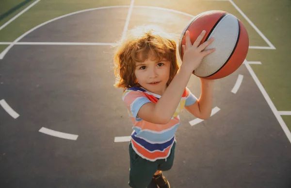Kinderjongen bereidt zich voor op basketbal schieten. Actieve levensstijl. Basketbal kinderen school. — Stockfoto