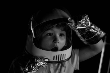 Çocuk astronot kaskı ve uzay kostümü giymiş. Uzay giysili küçük çocuk. Yaratıcı fikirler ve yenilik teknolojisi konsepti. Heyecanlı çocukların yüzünü kapatın..
