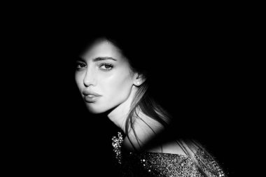 Stüdyoda poz veren genç bir kadın. Işık ve gölge. Yüzünde koyu renk ışık olan güzel bir kadının moda portresi. Kızların yüzü gölgeli, çekici kadın model..