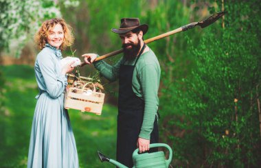 Bir çift çiftçi tarlada yürüyor. Bahçede filizlenen iki çiftçi..