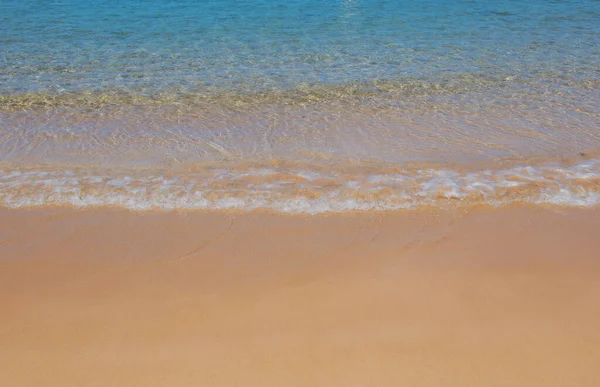 Onda blu oceano sulla spiaggia sabbiosa. Spiaggia al tramonto ora legale. Paesaggio balneare. Mare tropicale, calma, tranquilla e rilassante luce del sole. — Foto Stock