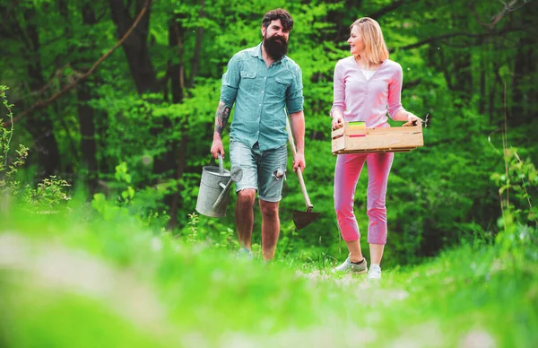 Ein paar Bauern, die auf einem landwirtschaftlichen Feld spazieren gehen. Gärtnern im Frühling - glückliche Paare ernten und viel Spaß haben. ein Paar Bauernhöfe, die im Garten arbeiten. — Stockfoto