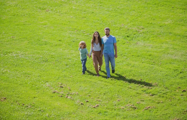 Porträt einer glücklich lächelnden Familie beim Spazierengehen im Park. Eltern und Kinder im Urlaub spielen gemeinsam im Freien. — Stockfoto