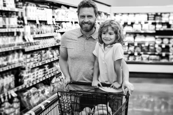 Far och son köper produkten i mataffären. Familj i butiken. — Stockfoto