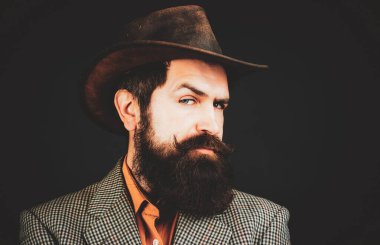 Geçmişi olan yakışıklı bir adam, siyah arka planda ciddi sakallı bir hippinin portresi..