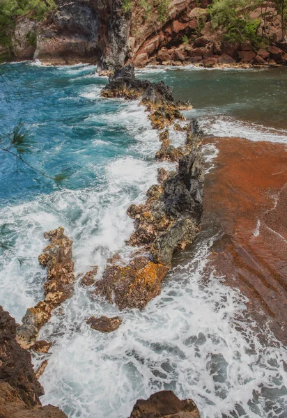 Океанічні хвилі розбиваються на скелястому узбережжі острова. Розщеплення океанських хвиль і каменів . — стокове фото