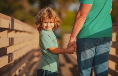 Arkadaş canlısı bir aile. Mutlu baba ve oğul. Oğul ellerini uzatıyor baba. Yakışıklı bir adam ve yakışıklı bir çocuk..