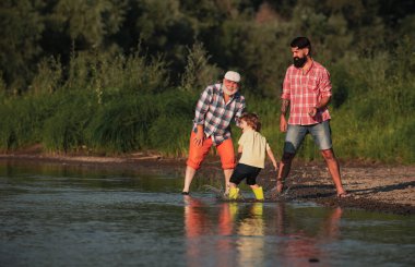 Üç kuşak aile. Büyükbabamla taş sektirme işi. Üç farklı nesil: büyükbaba ve çocuk birlikte..