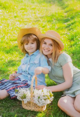 Piknikteki oğlunla Anneler Günün kutlu olsun. Parkta çimlerin üzerinde oturan çocuklu bir anne..