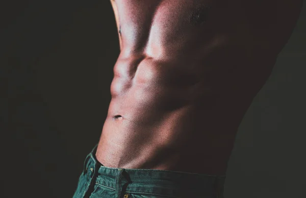 Masculine hard body. Fitness man showing six pack abs on grey background. — Stok Foto