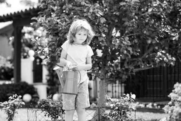 Kind im Blumengarten. Porträt eines Kindes, das im Garten arbeitet. — Stockfoto
