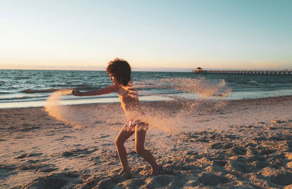 Joyeux garçon jouant dans la mer. Le gamin s'amuse dehors. Vacances d'été et mode de vie sain concept. Les enfants jouent avec le sable sur la plage d'été . — Photo