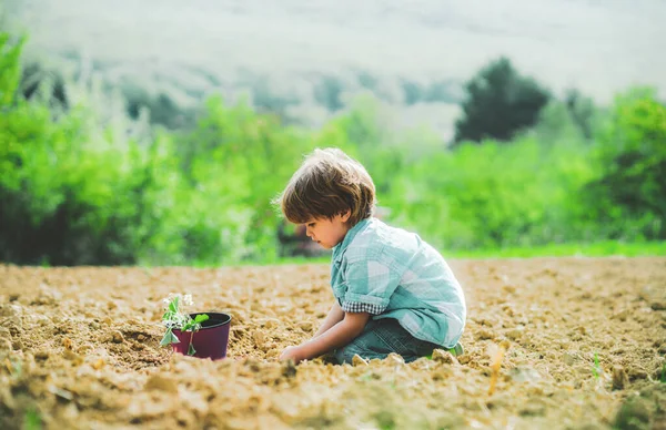 Barnbonde på gården med lantlig bakgrund. Blommor skötsel och vattning. Obekymrad barndom. — Stockfoto