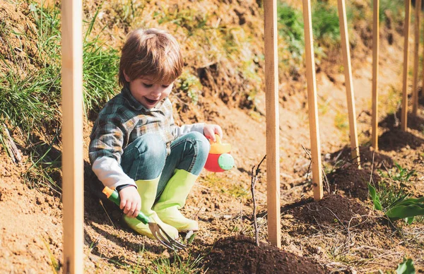 子供と一緒に庭を作る。花を植える。幼児は花公園で働いています. — ストック写真