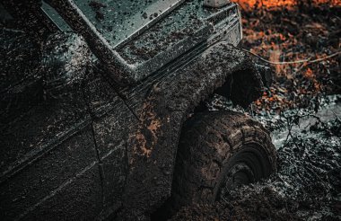 Off-Road aracı dağda gider. Alt görünümü büyük offroad araba tekerlek ülke road ve dağlar zemin üzerinde. Parça çamurlu sahada. Offroad araç bir çamur delik tehlikesi dışarı geliyor.