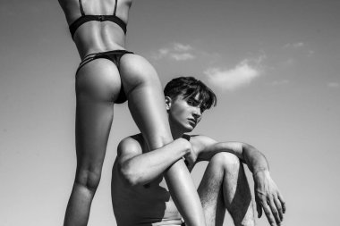 Womens legs and butt. Sexy hot girl wearing luxury bikini bottoms. Sexy couple in love. Sensual boyfriend embraces lovers. The concept of tenderness and affection.
