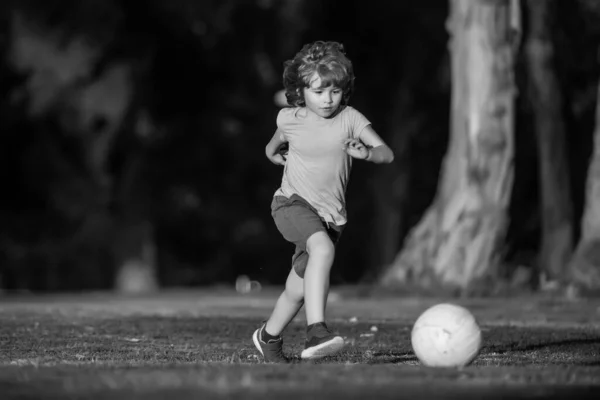 Chłopiec kopie piłkę nożną na boisku podczas meczu piłki nożnej. Młode sportowe dzieci. — Zdjęcie stockowe