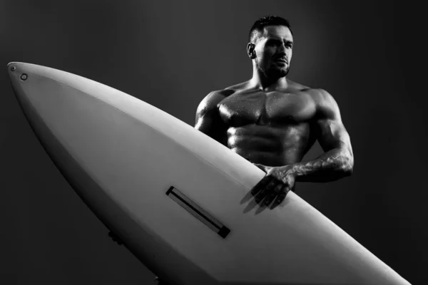 Sexy surfer met een surfplank. Portret van een knappe atleet met lijfplank. Mannelijke strand recreatie, zomervakantie. — Stockfoto