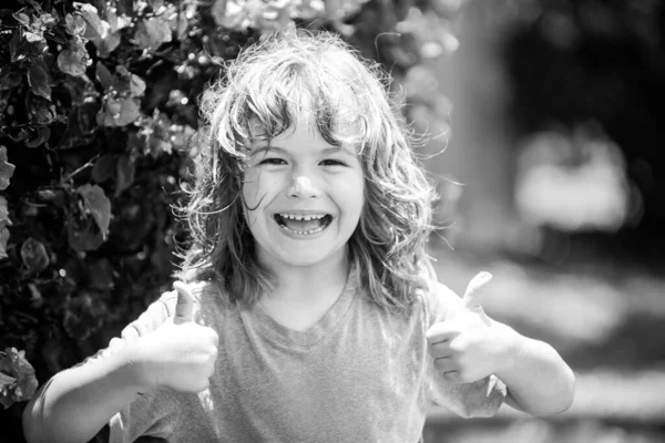 Portrét šťastného smějícího se dítěte. Zavřít pozitivní dětský obličej, palec nahoru. — Stock fotografie