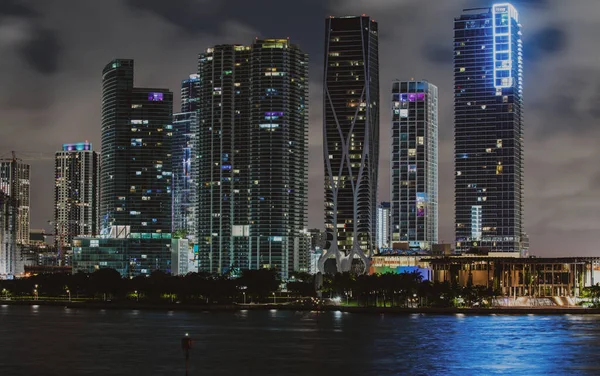 Miami Florida vid solnedgången, skyline av upplysta byggnader och Macarthur Causeway bron. Miaminatten. — Stockfoto