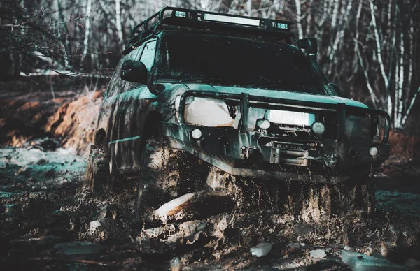 Caminhão desportivo off-road entre montanhas paisagem. Rastrear na lama. Fora do carro. Safari. Os melhores veículos off-road. Jeep esmagado em um remo e pegou um spray de sujeira . — Fotografia de Stock