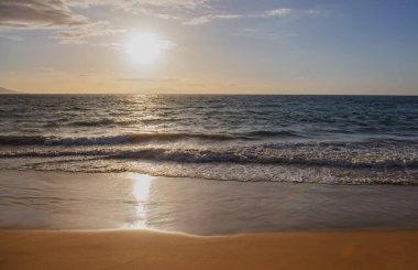 Gün batımı. Altın kumu olan sahil, turkuaz okyanus suyu. Panoramik deniz manzarası. Yaz tatili için doğal arka plan.