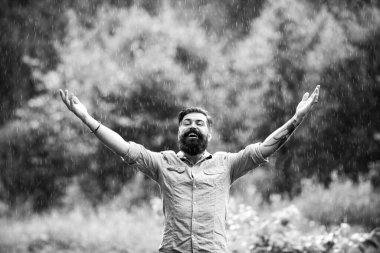 Sonbahar yağmurlu hava konsepti. Su geçirmez giysi. Yağmur altında mutlu bir adam.