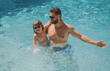 Baba oğul havuzda yüzüyor, yaz ailesi. Babası yüzme havuzunda oynayan bir çocuk. Yaz tatili. Aquapark. Baba oğul boş vakit..