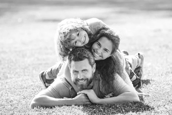 Familia abrazo y abrazo en la hierba en el parque. —  Fotos de Stock