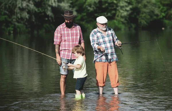 Abuelo, padre e hijo pescando juntos. Gente feliz familia tienen la pesca y la diversión juntos. Día de verano. Vida activa al aire libre . — Foto de Stock