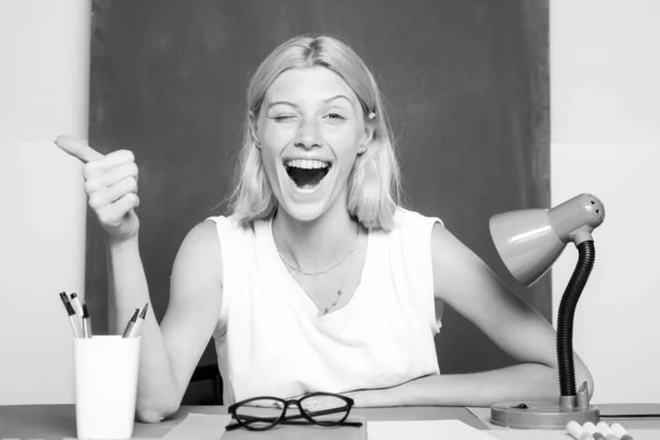 Learn with fun. Funny female teacher sitting at her workplace and teaching English. Happy funny teacher winking. Education concept. Good idea. — Stock Photo, Image