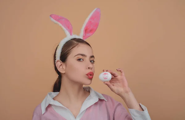 Usta i Wielkanoc, szminka pocałunek nadruk na easter egg. Wesołych Świąt. Młoda kobieta królik bunny uszy. Portret kobiety szczęśliwy w uszy królika. Polowanie na jajka. — Zdjęcie stockowe