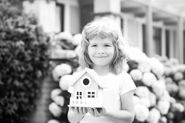 Chłopiec z małą zabawką drewniany dom, nowa koncepcja domu. — Zdjęcie stockowe