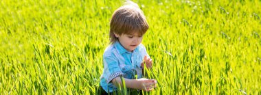 Bahar çocukları portresi olan pankart. Çiftçi çocuk tarlada ya da tarlada incir mahsulünü inceliyor. Yeşil çim arka plandaki çocuklar.