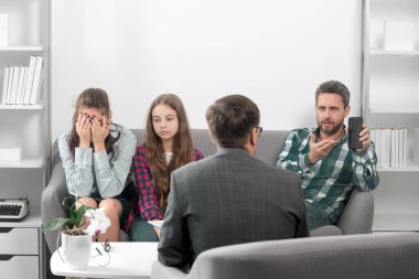 Genç çocukların sorunlarını çözmek için genç bir aileye yardım eden psikolog. Ebeveyn kavramı. Sosyal medya sorunu.