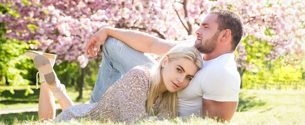 Casal de primavera apaixonado, banner. Duas pessoas relaxando em flores sakura. Marido e esposa relacionamento romântico. — Fotografia de Stock