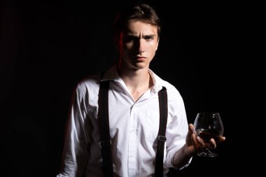 Bir bardak viskisi olan adam. Pahalı bir içki. Erkek brendi ya da konyak içiyor. Degukasyon, tatma.