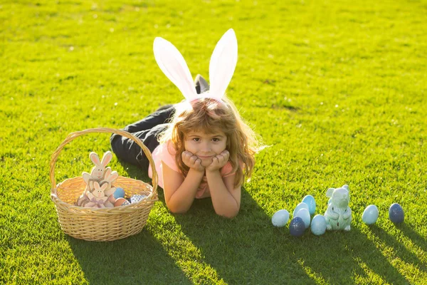 Jongetje met paaseieren en konijnenoren buiten. Leuk kind met gelukkig Pasen in het park. Vrolijk Pasen. — Stockfoto