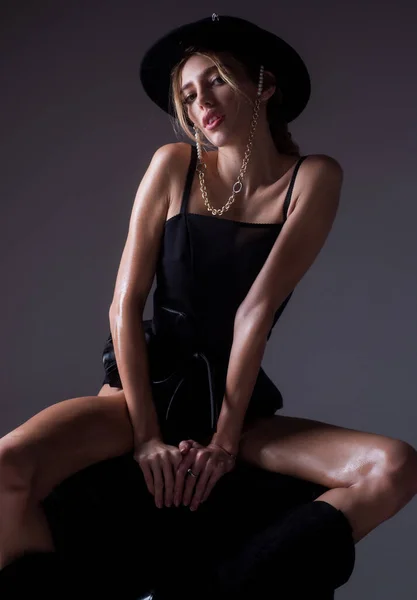 Modelo de mujer de moda en sombrero sobre fondo de estudio aislado. Retrato de alta moda de mujer joven y elegante, toma de estudio. Bastante joven dama en una pose de moda. — Foto de Stock