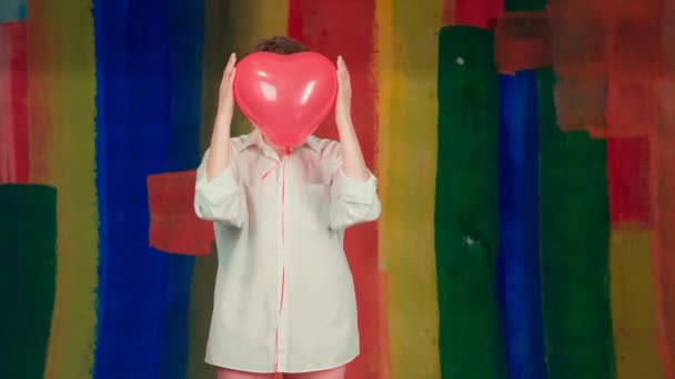 Love rain on Saint Valentines Day concept. Young woman with emotional face and heart balloon. — Stock Video