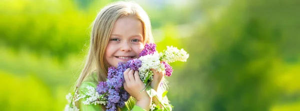 Bannière avec portrait d'enfants de printemps. Joyeux jeune fille dans le jardin avec de longs cheveux blonds étant excité d'obtenir un bouquet de lilas sur la journée des femmes. Enfants sur fond d'herbe verte. — Photo