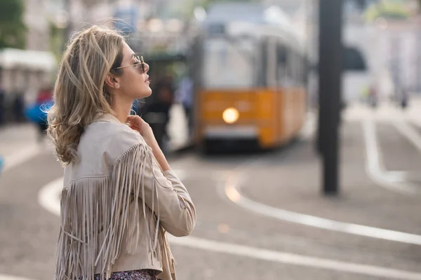 女性のストリートスタイル。トロリーバスの背景にある街の通りのファッションモデル。ファッション都市の服。普段着. — ストック写真