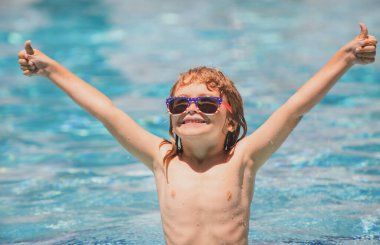 Yaz yüzme havuzunda bir çocuk. Havuzdaki aktiviteler, yüzen ve oynayan çocuklar, mutluluk çocukları ve yaz zamanı.