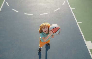 Çocuklar spor yapıyor. Basketbol oynayan ve basketbol oynayan çocuklar, geniş açıdan bakın..