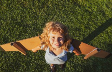 Çocuk hayal gücü parktaki yeşil çimlerde pilot olmayı hayal eder. Yaratıcı ve yenilikçi kavram. Başarı çocuklar ve lider konsepti.