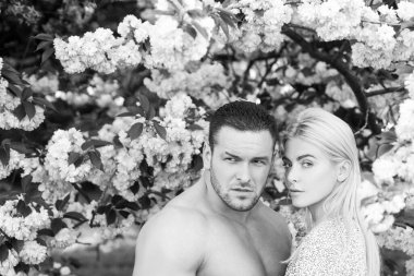 Bahar çiçekli arka plandaki genç çift. Aşıklar romantik anlar yaşıyor.